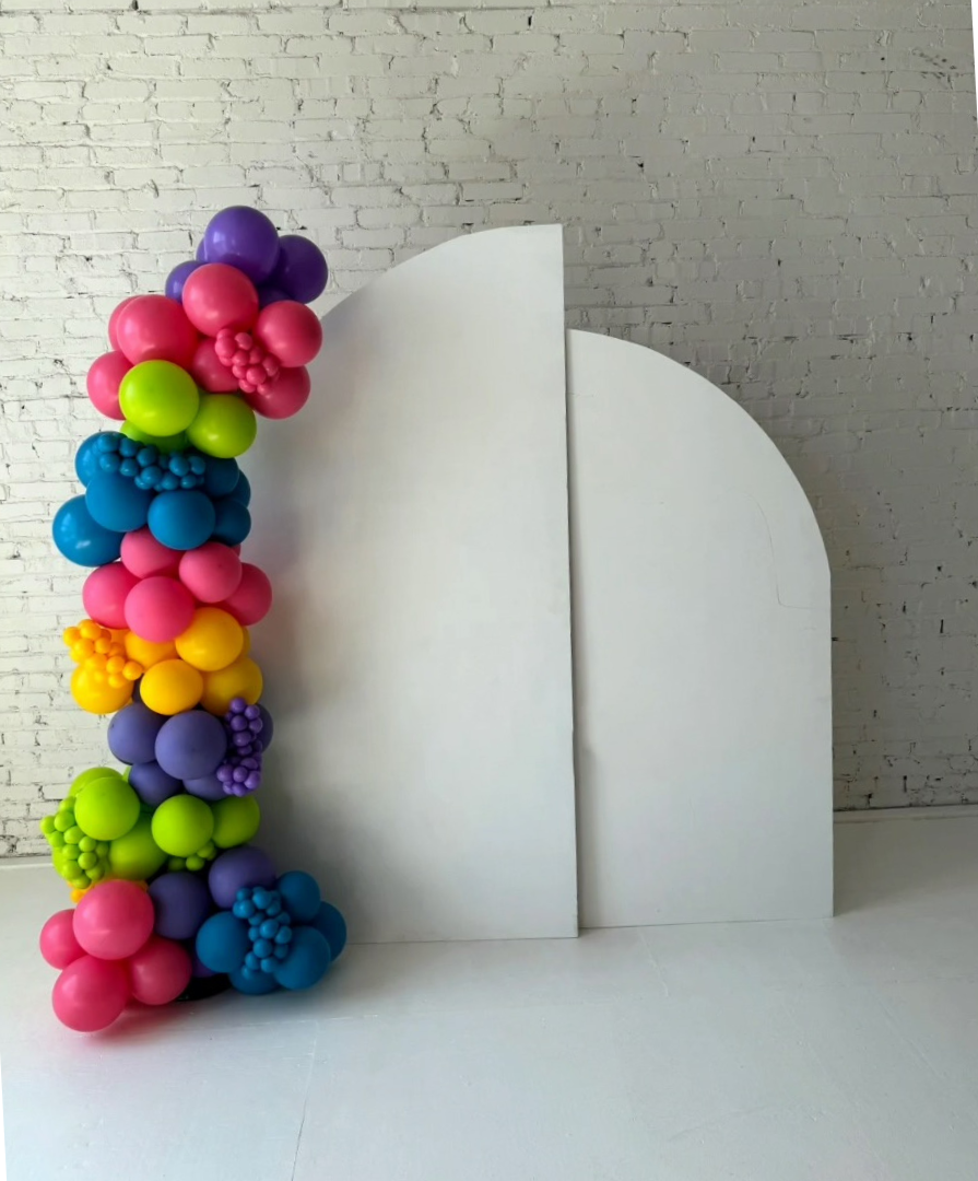 White arched backdrop panel with balloon garland by Lady With The Balloons in Leawood, Kansas — ideal for party setups and event backdrops.