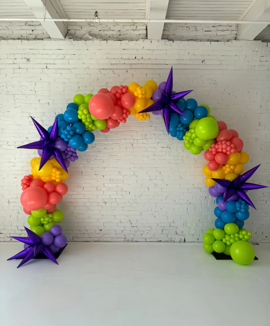 Freeform organic balloon arch installation by Lady With The Balloons in Leawood, Kansas — featuring metallic starburst balloons and vibrant colors for modern event décor.
