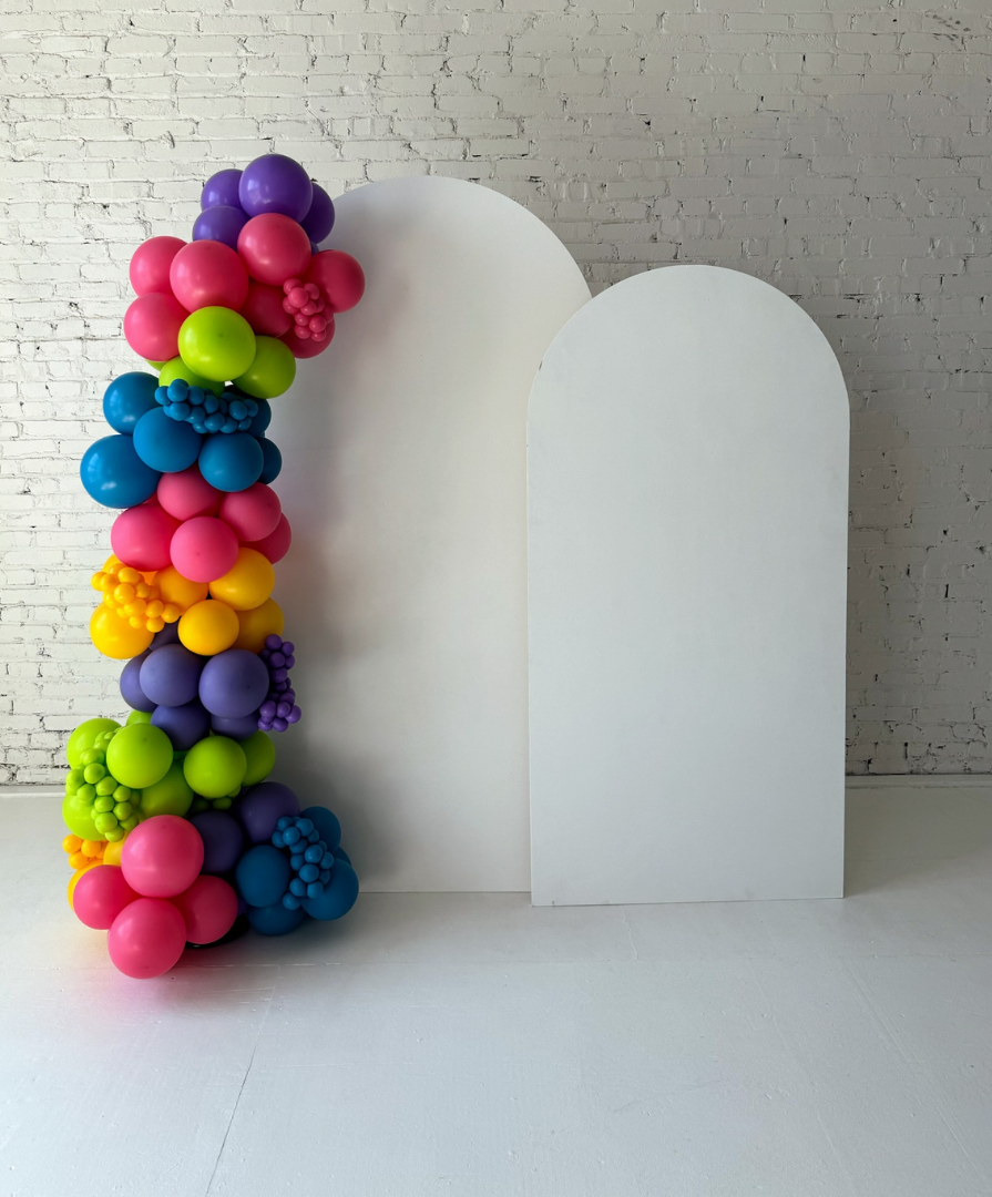 White arched backdrop panel rental with colorful balloon garland installation by Lady With The Balloons in Leawood, Kansas — perfect for photo areas, baby showers, and celebrations.
