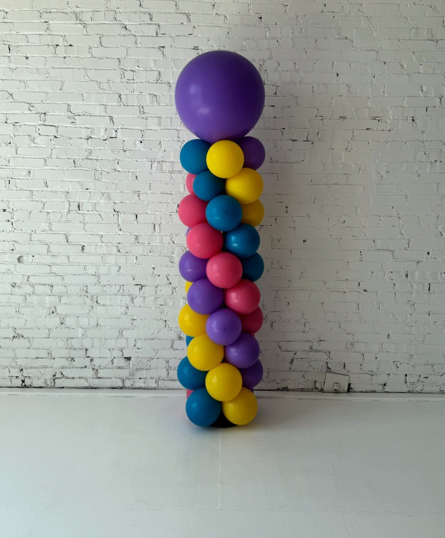 Classic balloon column installation by Lady With The Balloons in Leawood, Kansas — featuring vibrant purple, teal, yellow, and pink balloons stacked in a spiral design, perfect for birthdays, graduations, and grand openings.
